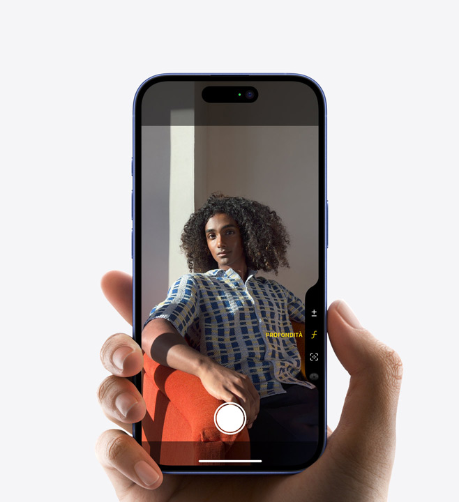 Un iPhone 16 Pro con un pollice appoggiato sul tasto del Controllo fotocamera per regolare la profondità di campo