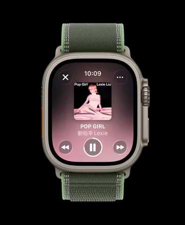 原色鈦金屬錶殼，搭配綠色配霓虹綠色越野錶環的 Apple Watch Ultra 3，展示 Apple Music 的體能訓練歌單，以及上一首、下一首、暫停等控制選項