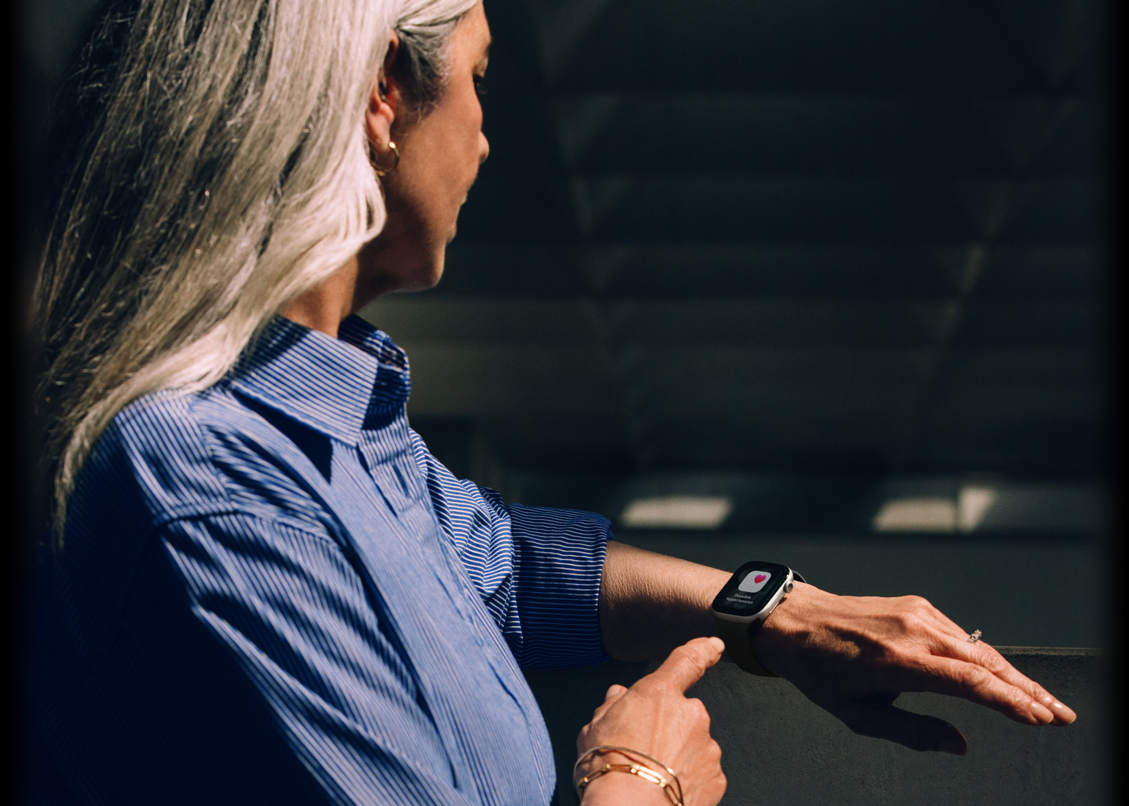 Iemand leest een melding over een mogelijk hoge bloeddruk op een Apple Watch Series 11