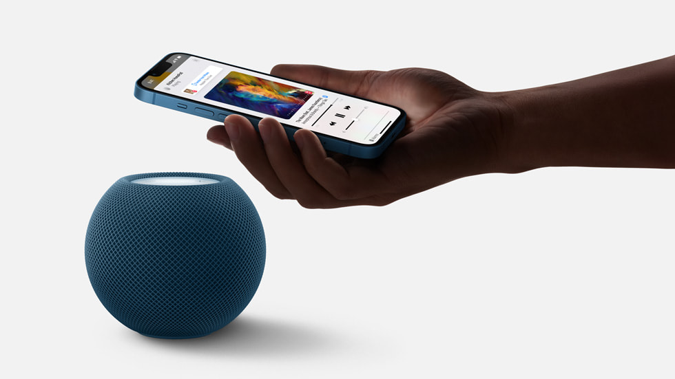 En bruger holder sin iPhone over sin HomePod-højttaler.