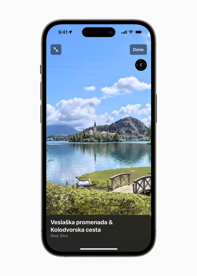 Używanie funkcji Rozejrzyj się w nowych Mapach na iPhonie 14 Pro do eksploracji okolic jeziora Bled.
