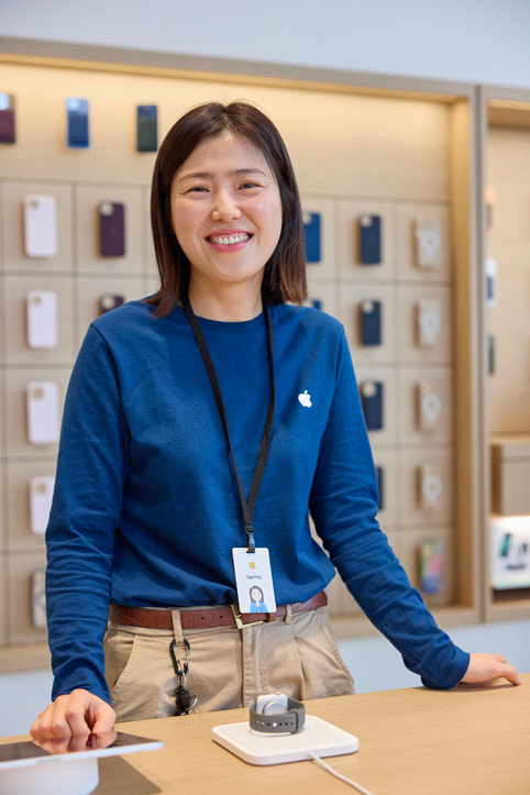 Apple 홍대 내부에서 미소를 짓고 있는 Apple 팀원의 모습.