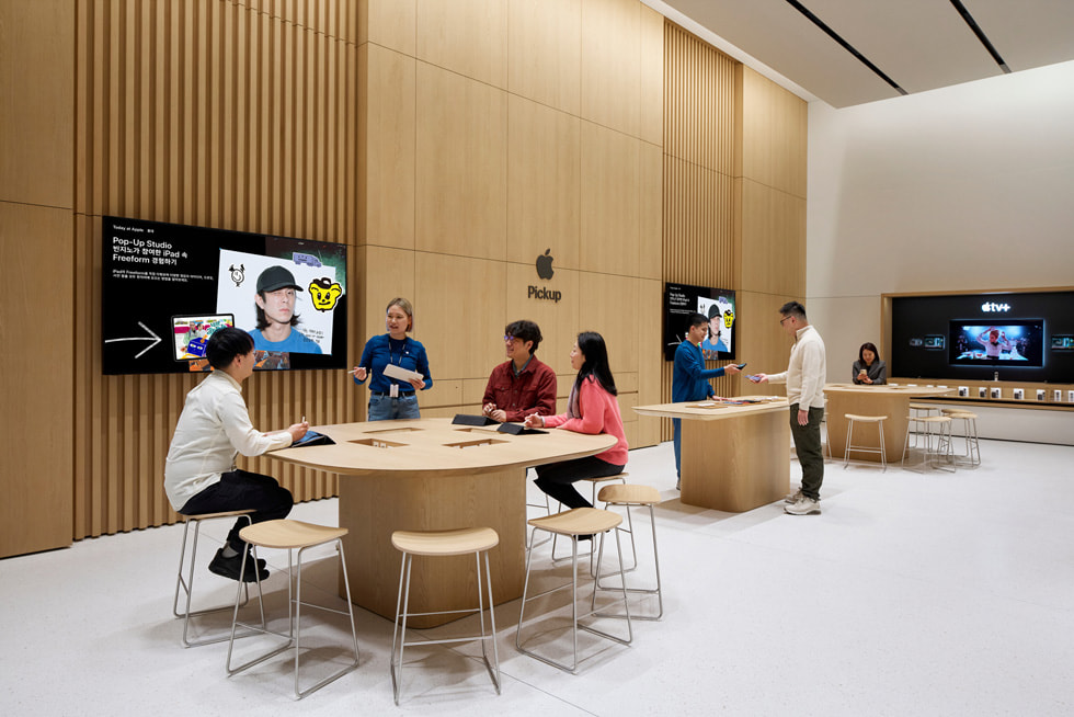 Apple 홍대 내부 Today at Apple 테이블에 착석한 고객들의 모습.