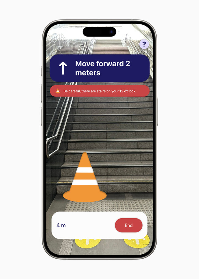 iPhone 15 Pro’da PetaNetra uygulamasından bir ekran görüntüsünde “2 metre ileri gidin” yönergesi ve “Dikkat edin, saat 12 yönünde basamaklar var” yazan bir uyarı görülüyor.