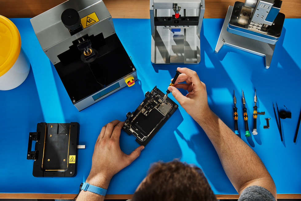 Bir iPhone’da Self Service Repair işlemi yapan bir kişinin üstten çekilmiş görüntüsü.