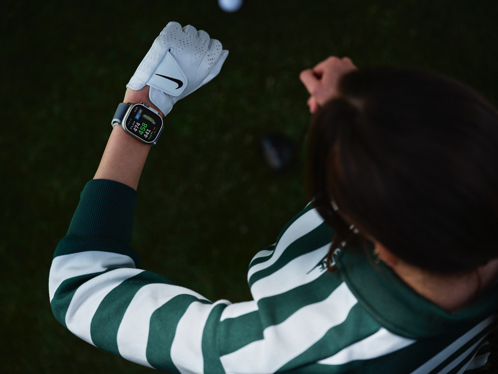 En golfer som ser på Apple Watch er vist ovenfra.