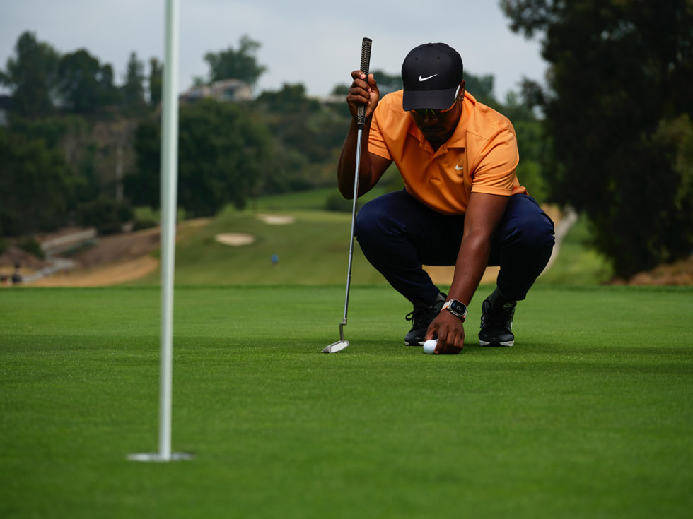 Bilde av en golfer som har på seg en Apple Watch og forbereder en putt.