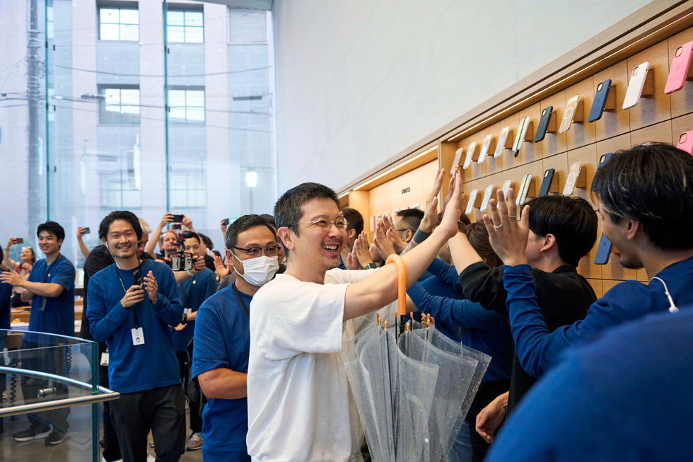 Un cliente choca los cinco con los integrantes de Apple en la fila dentro de Apple Omotesando.