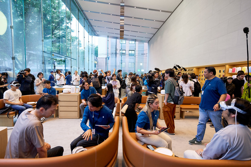 Una foto panorámica muestra a varios clientes e integrantes del equipo dentro de la concurrida tienda Apple Omotesando.