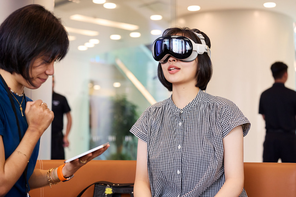 Una integrante del equipo Apple sentada con una clienta que usa un Apple Vision Pro.