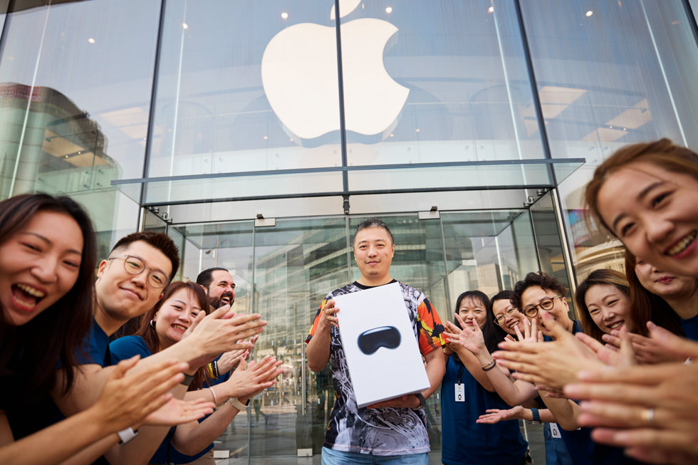 Integrantes de Apple celebran mientras un cliente sale de Apple Wangfujing con un Apple Vision Pro en su caja.