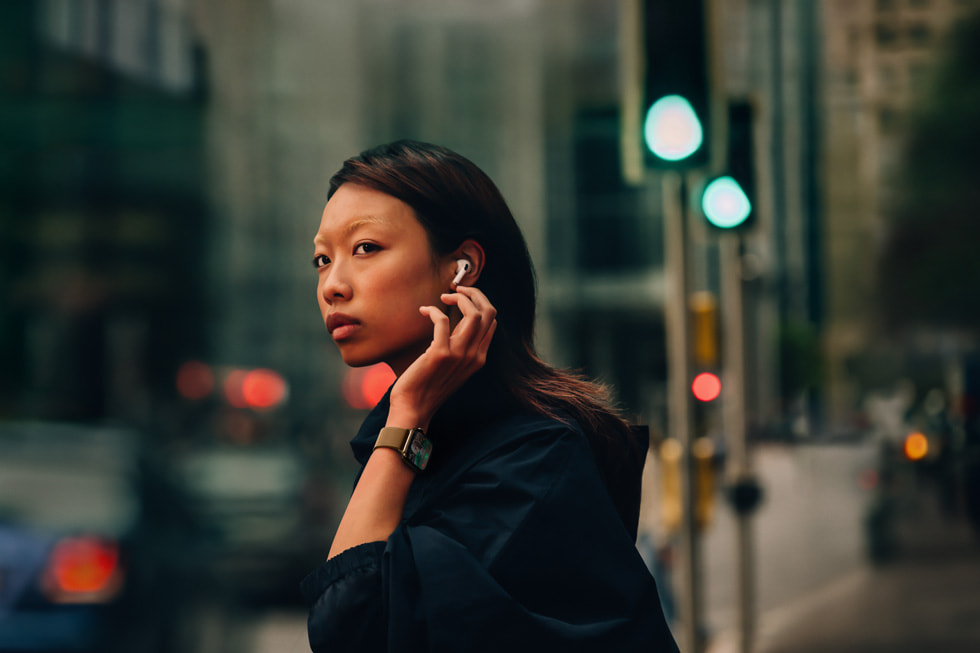 Một người ở trên phố đang đeo AirPods 4 và Apple Watch Series 10.