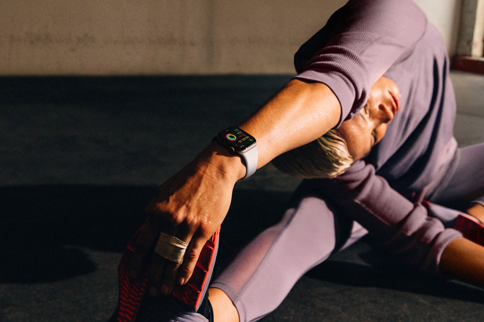 Một người đeo Apple Watch Series 10 đang thực hiện động tác kéo dãn tương tự như một tư thế yoga.