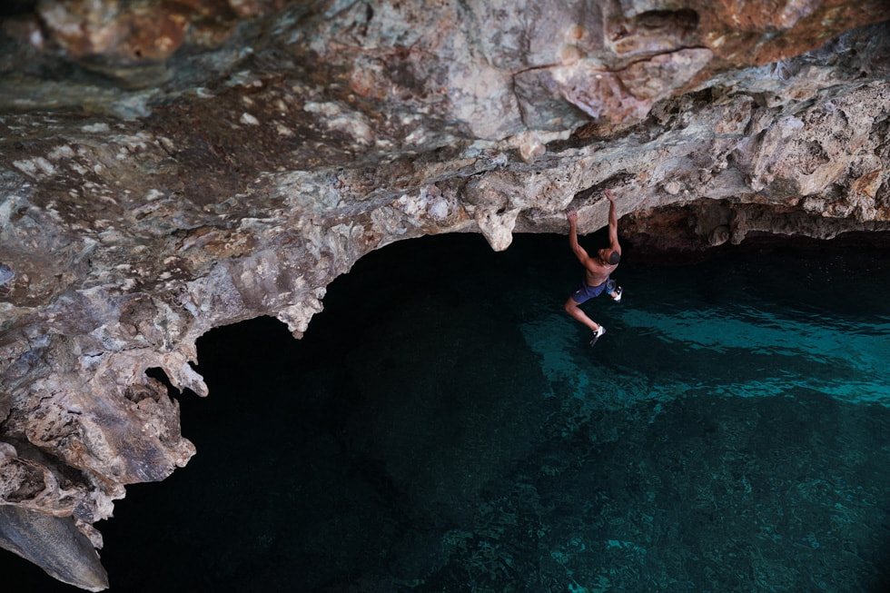 Kai Lightner suspendu à une falaise au-dessus de la mer dans l’épisode « Free Solo » de la série Adventure.