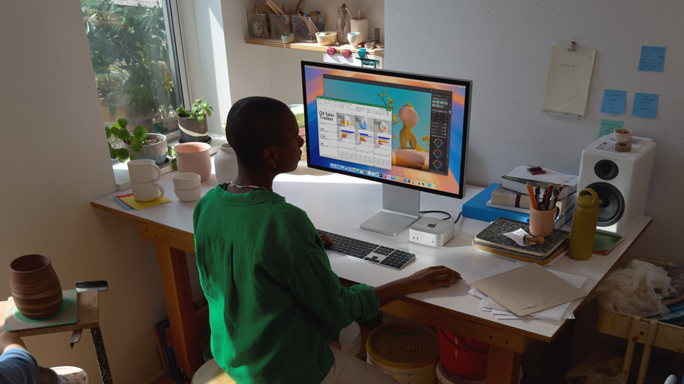En Mac mini-användare arbetar vid ett skrivbord omgiven av keramikföremål.