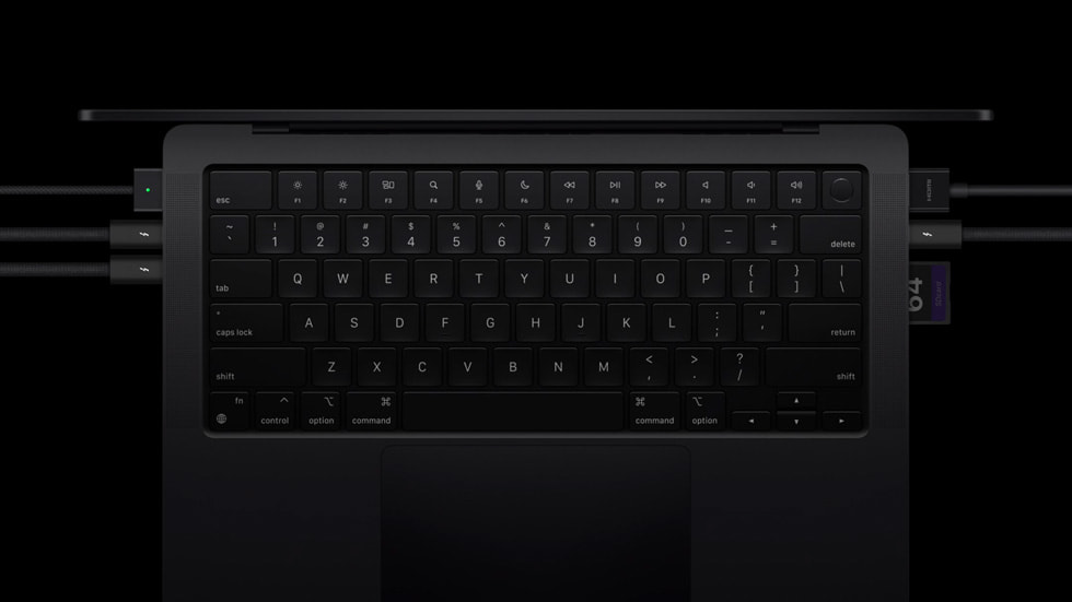 MacBook Pro klavyesinin, Thunderbolt 5 bağlantı noktası ve ona bağlı çevre birimlerle yakından görünümü.