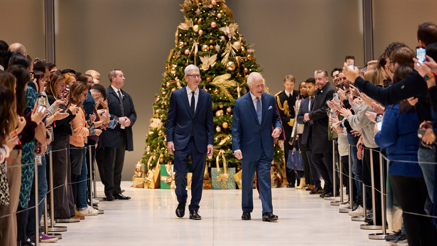 Snímek atria pořízený v sídlu Applu v elektrárně Battersea, na kterém je zachycený Tim Cook, král Karel a členové týmu Applu.