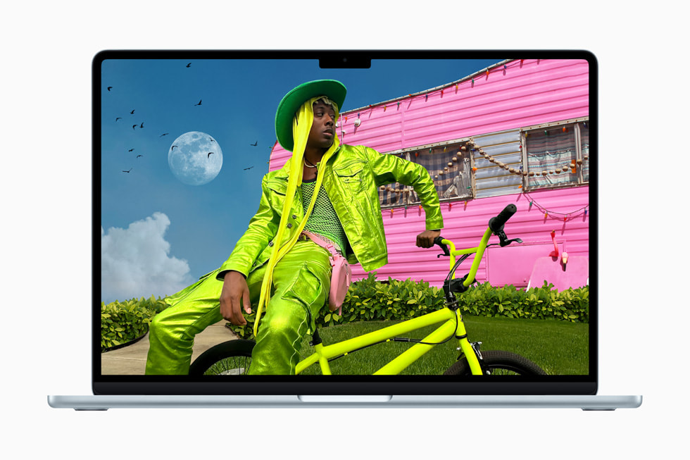 MacBook Air에 형광 초록 색상의 옷을 입고 형광 초록 색상의 자전거를 탄 채 형광 분홍 색상의 캠핑카 앞에 서 있는 사람을 찍은 독특한 사진이 표시되어 있는 모습. 