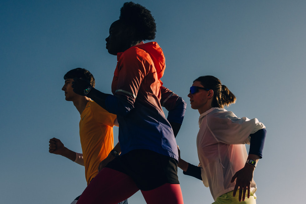 Drie mensen die buiten hardlopen met Apple Watch Series 11.