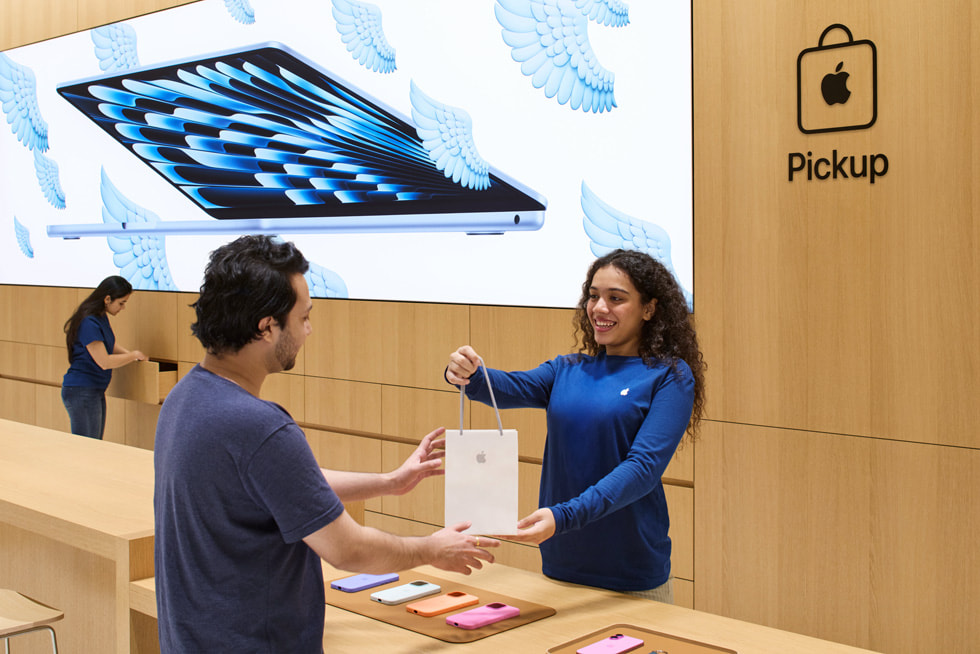 Apple Koregaon Park 零售店內，團隊成員在 Apple Pickup 取貨專區協助顧客。