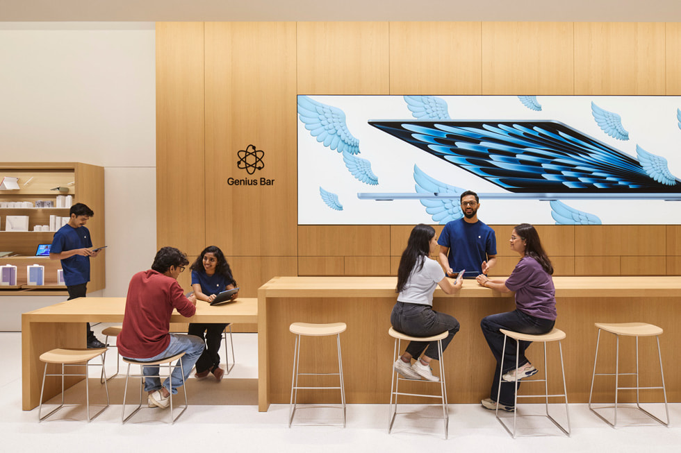Apple Koregaon Park 零售店內，團隊成員在 Genius Bar 天才吧協助顧客。
