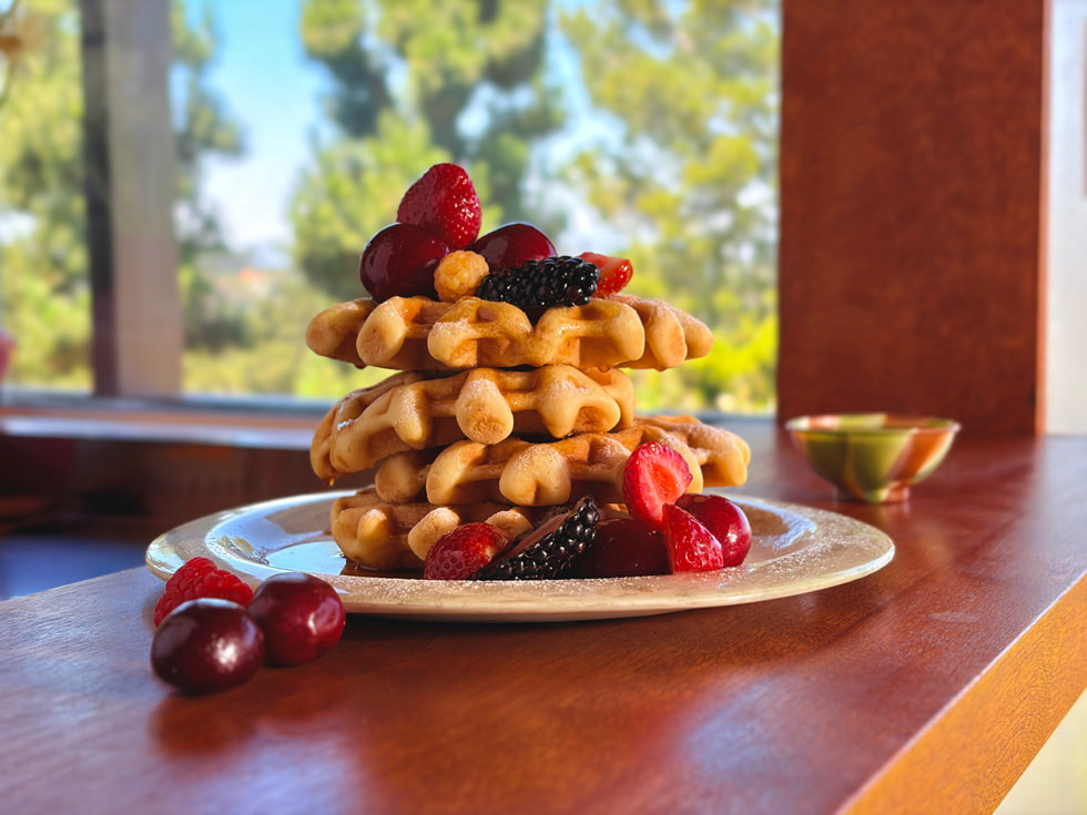 A close-up photo of a stack of homemade waffles covered in colourful berries showing Focus Control on iPhone Air.