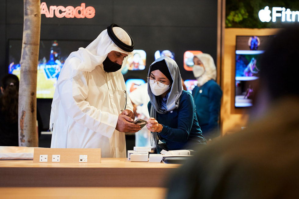 أحد أعضاء الفريق يساعد عميلاً داخل متجر Apple بجزيرة المارية. 