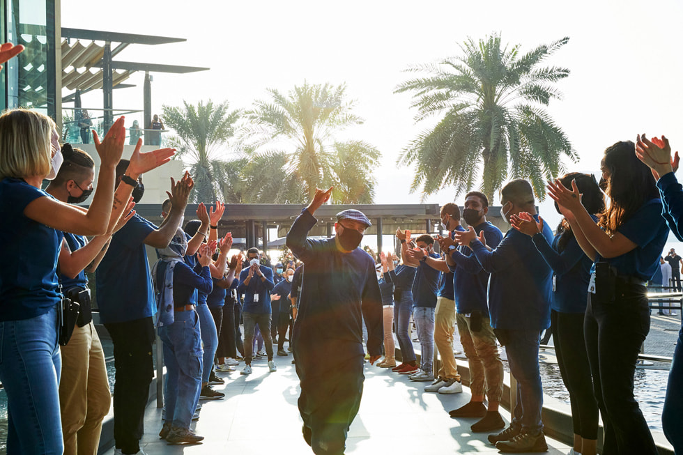 أعضاء فريق العمل يرحبون بأوائل العملاء أثناء افتتاح متجر Apple بجزيرة المارية. 