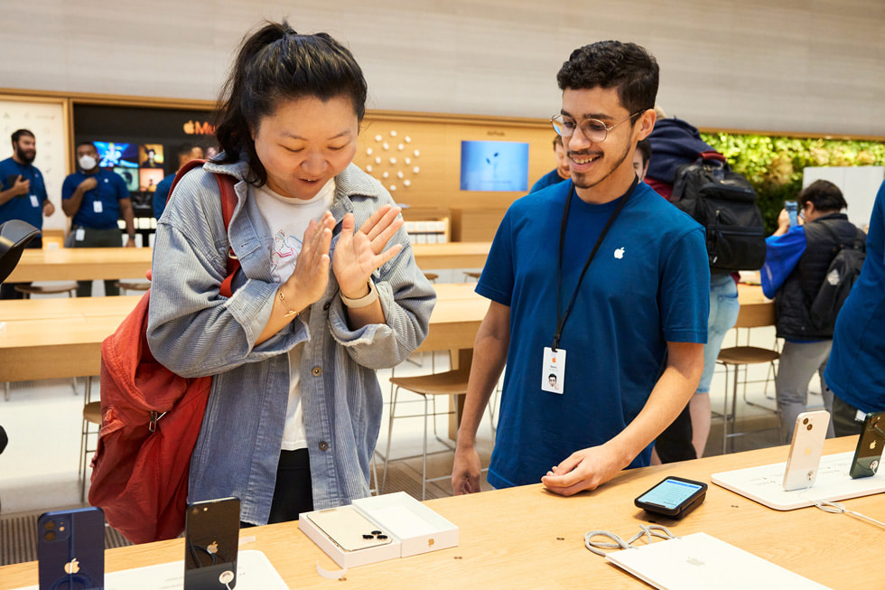 عميلة تفتح علبة جهازها iPhone 14 Pro الجديد بلون ضوء النجوم.