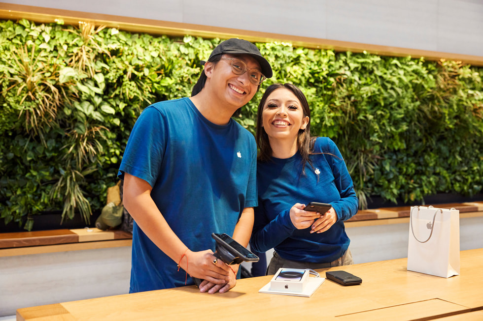 عضوان من فريق Apple Park Fifth Avenue ينظران إلى أحد العملاء. 