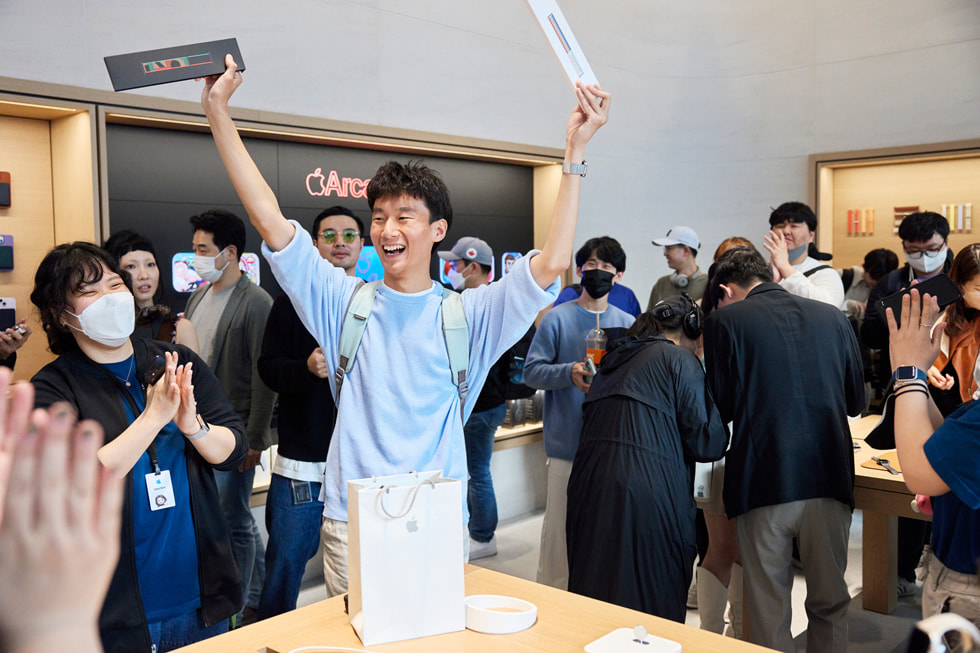 Apple 강남에서 고객이 두 개의 Apple Watch 밴드를 들고 있다.