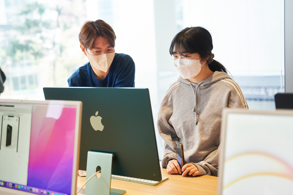En medarbetare tar hand om en kund vid invigningen av Apple Myeongdong.