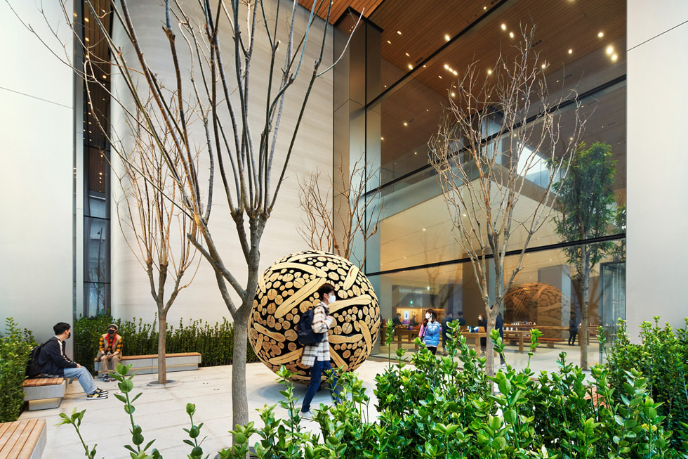 Kunder udforsker en lille have udenfor Apple Myeongdong.