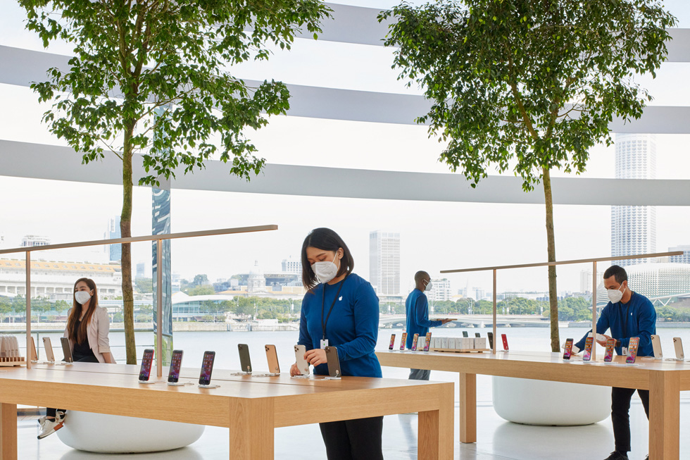 Et Apple-teammedlem indstiller en iPhone på skærmholdere.