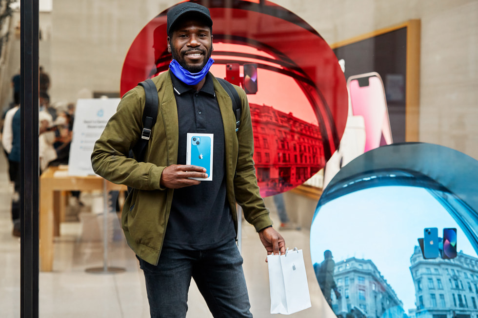 En kunde i Apple Regent Street viser sin nykøbte iPhone 13 frem. 