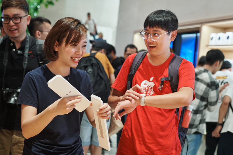 Un membre de l’équipe d'Apple Xinyi A13 aide un client avec une Apple Watch.