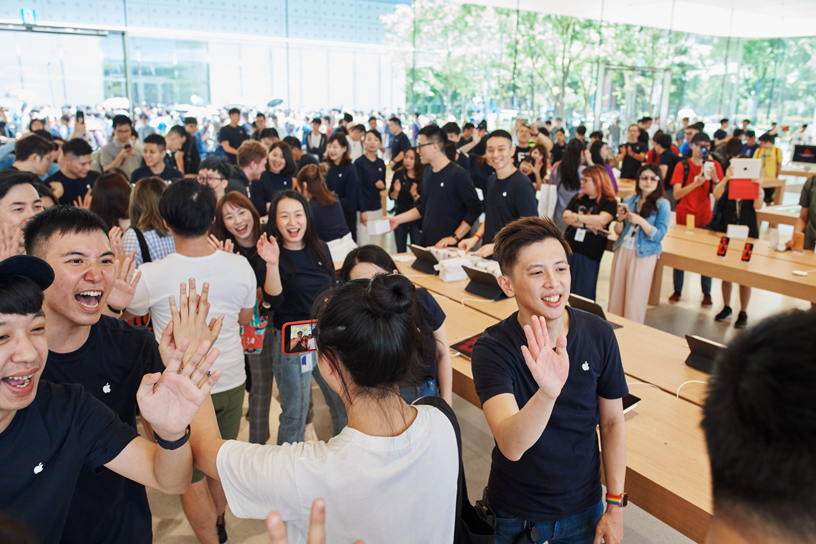 Des membres de l’équipe d’Apple Xinyi A13 et des clients dans le magasin.