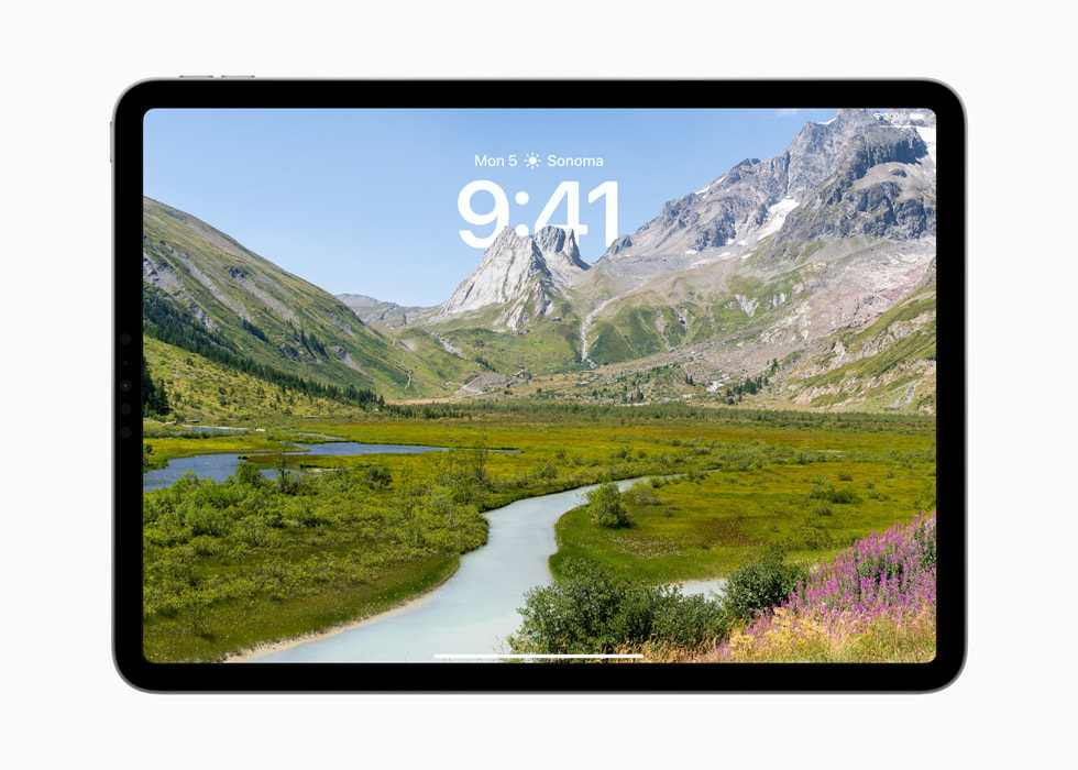 Op het toegangsscherm van een iPad Pro is vóór de tijd een afbeelding van een berg te zien.