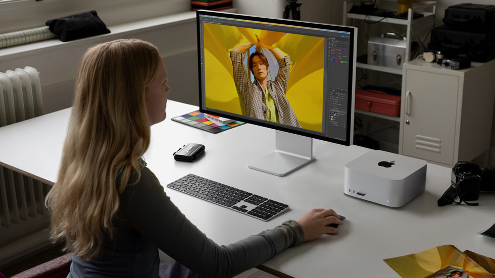 Mac Studio ve Mac Pro kullanan bir kişi iş istasyonunda oturuyor.