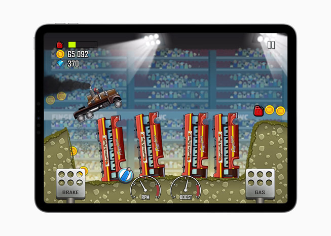 iPad Pro’da Hill Climb Racing+ oyununda bir canavar kamyonu itfaiye araçlarıyla dolu bir çukurun üzerinden atlarken gösteren bir görüntü.