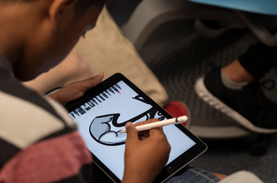 Un étudiant dessinant sur iPad avec l'Apple Pencil.