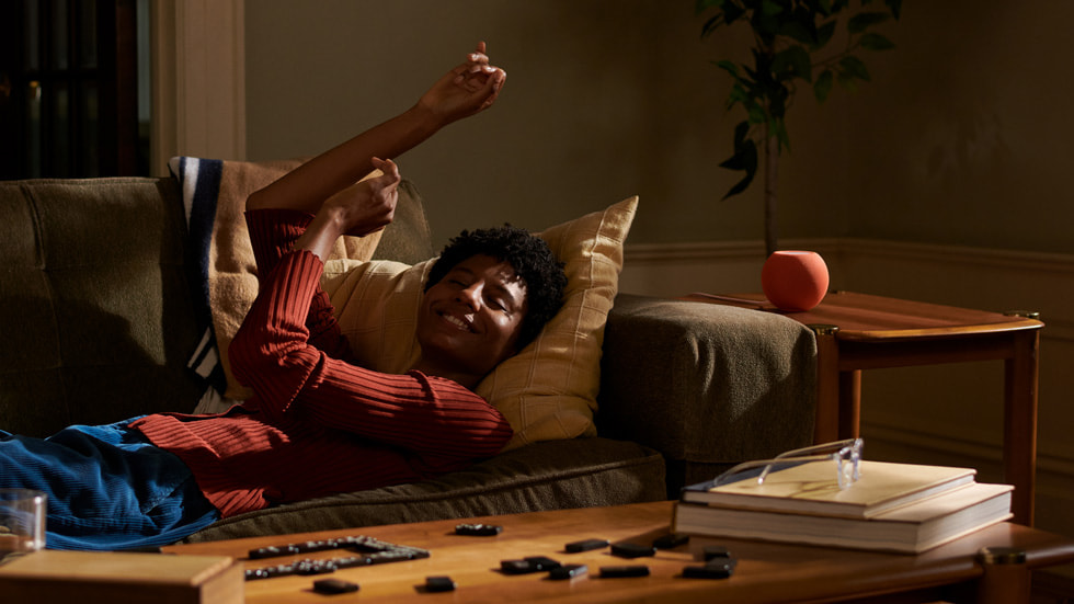 HomePod miniで音楽を聴きながらくつろぐ男性。