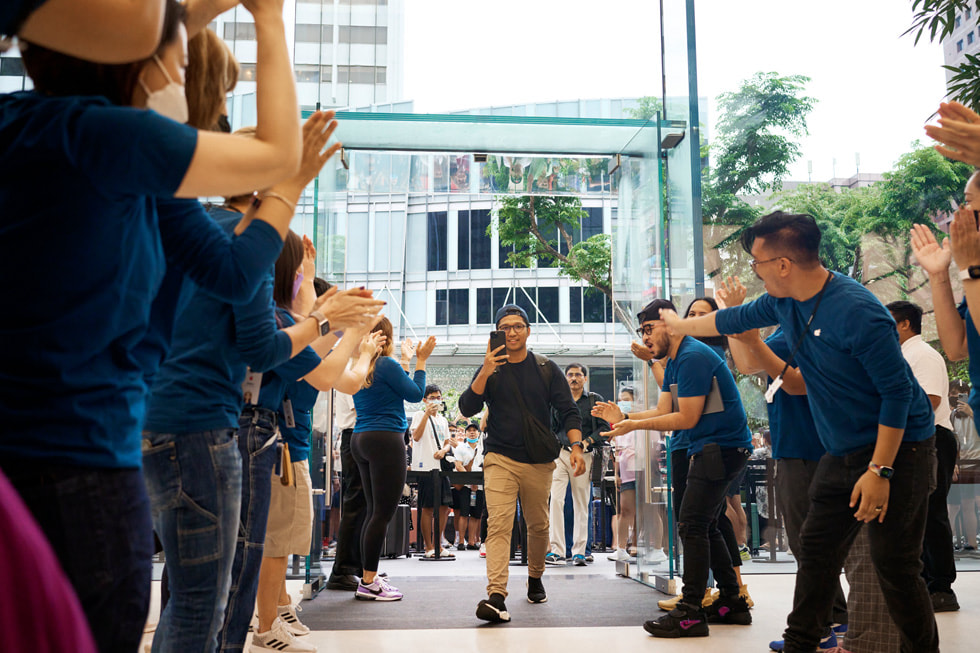 أعضاء فريق متجر Apple Orchard Road يحيون عميلاً يدخل المتجر.