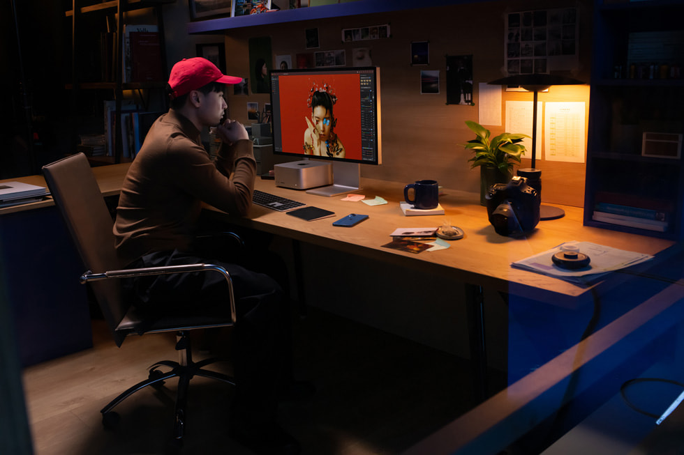 Bir yaratıcı profesyonel ofis ortamında Mac Studio ve Studio Display ile çalışıyor.