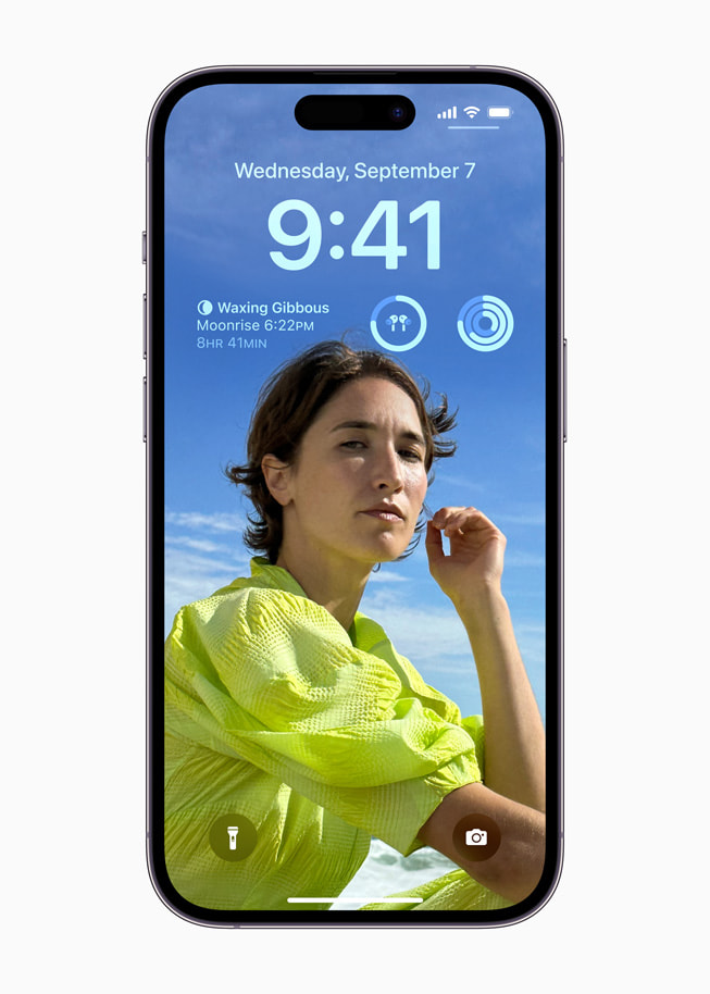 iPhone 14 Pro’da iOS 16’daki kişiselleştirilmiş Kilit Ekranı ve araç takımları gösteriliyor.