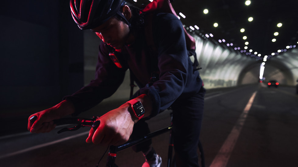 Apple Watch Series 7을 착용하고 야간에 터널을 지나고 있는 자전거 라이더.