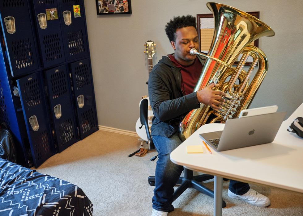 Rhys Richard practices the tuba alongside iPad Pro and MacBook Pro.