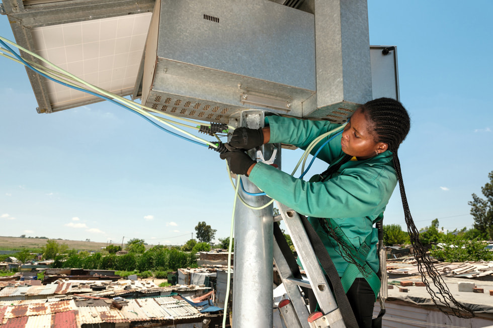 Painel solar em instalação no topo de um poste na cidade de Diepsloot na África do Sul.